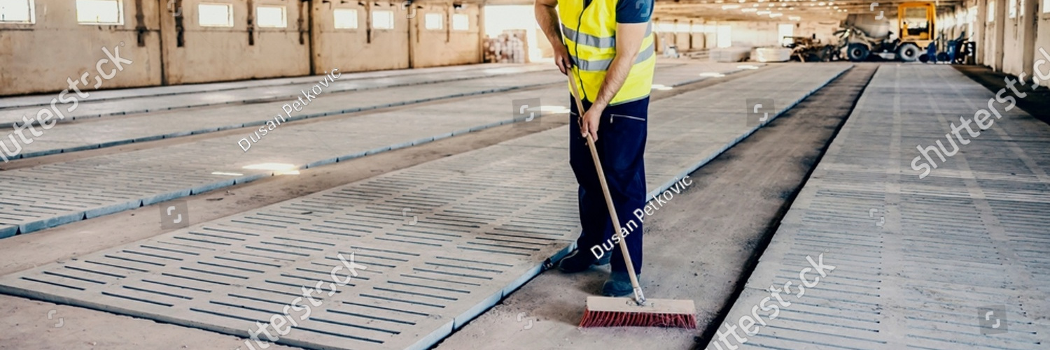 stock photo a tidy worker brooming surfaces at construction site 2122355795