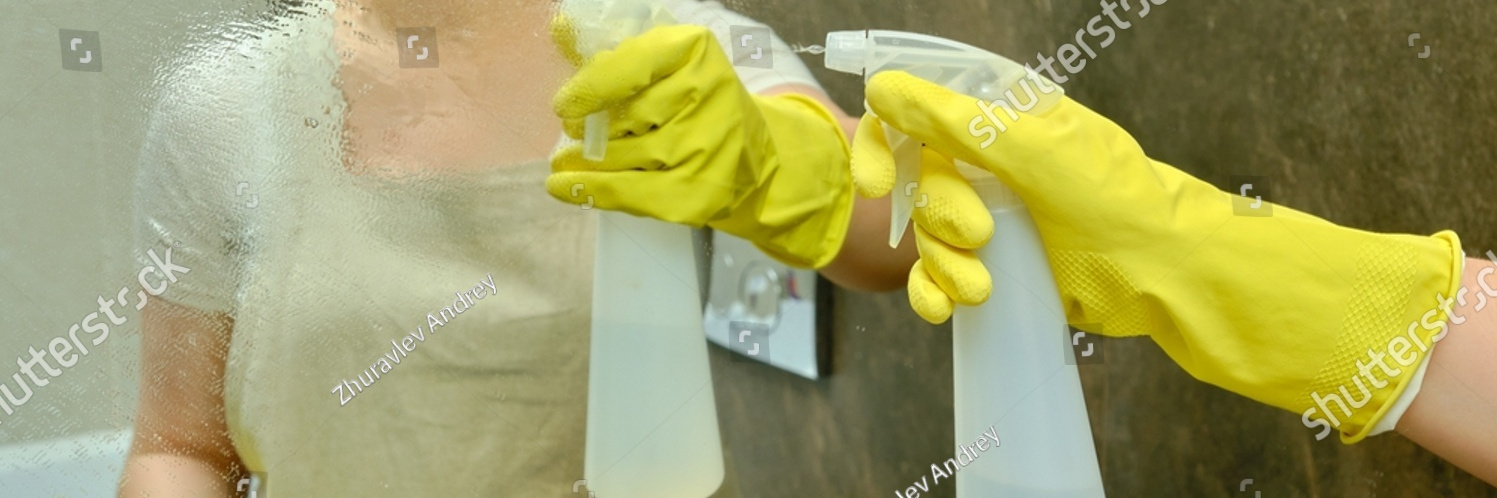 stock photo a woman is cleaning the bathroom by wiping the mirror with a rag disinfection with yellow rubber 2056077194