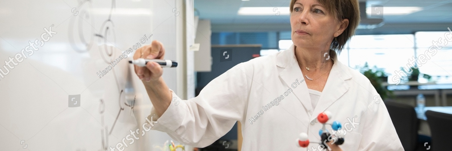 stock photo female chemistry professor with molecule model writing on whiteboard in science classroom 2217915057
