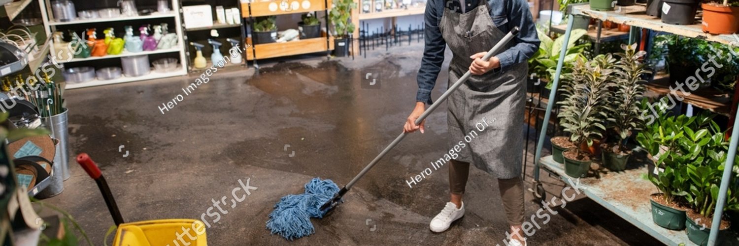 stock photo female worker mopping floor with mop in garden shop 2254102297