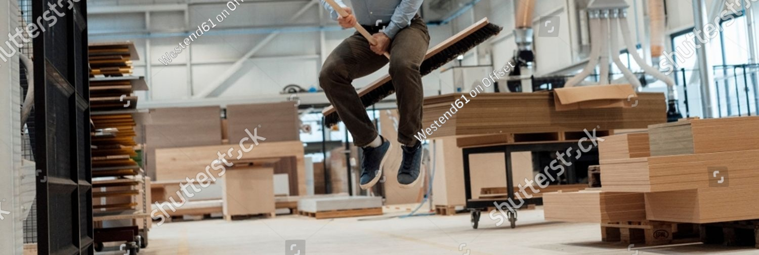 stock photo happy young businessman jumping with broom in industry 2317787771