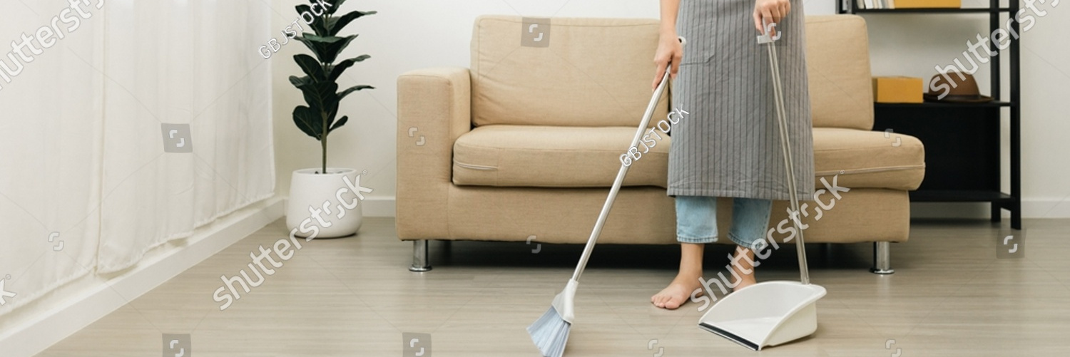 stock photo housewife using broom and dustpan wearing an apron to clean the living room at apartment young 2183431397