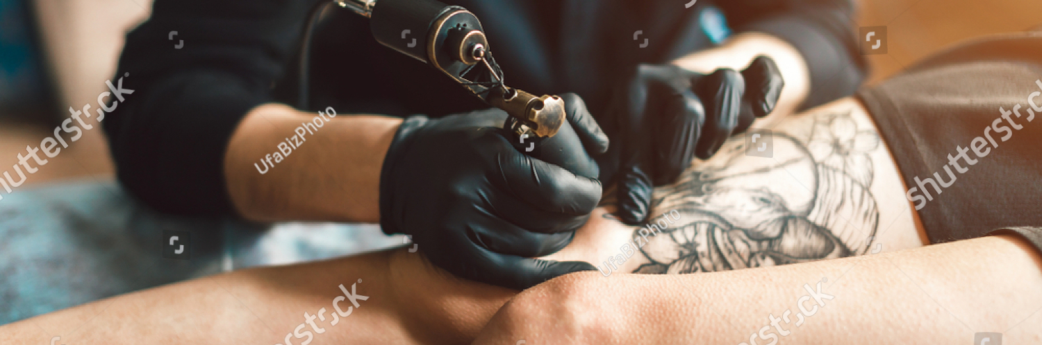 stock photo tattoo artist in black gloves making a tattoo on the foot girls sterile 1028327695
