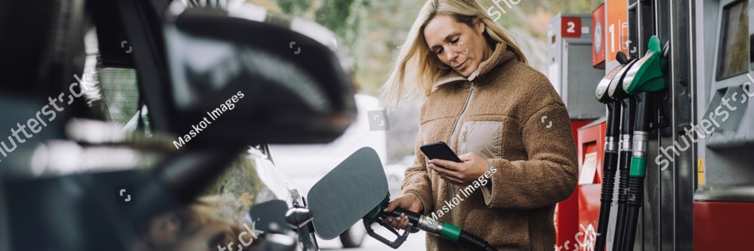 stock photo woman using mobile phone while refuelling car at gas station 2256674431