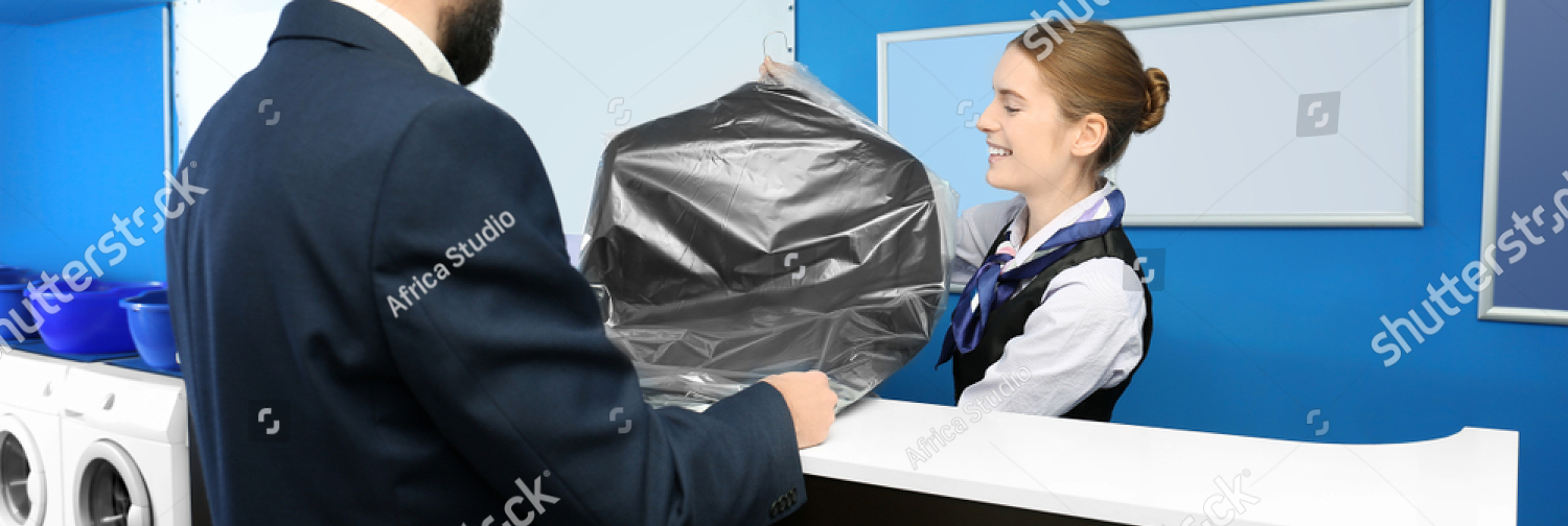 stock photo young man receiving his clean suit from laundry worker at reception 1095345953